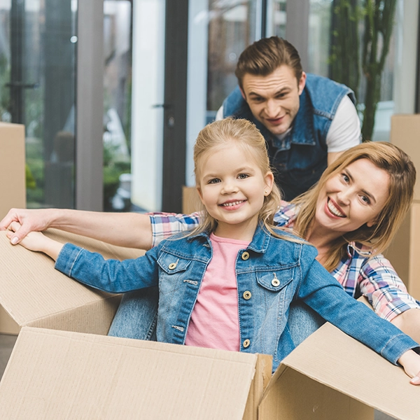 Una familia jugando con las cajas de la mudanza.