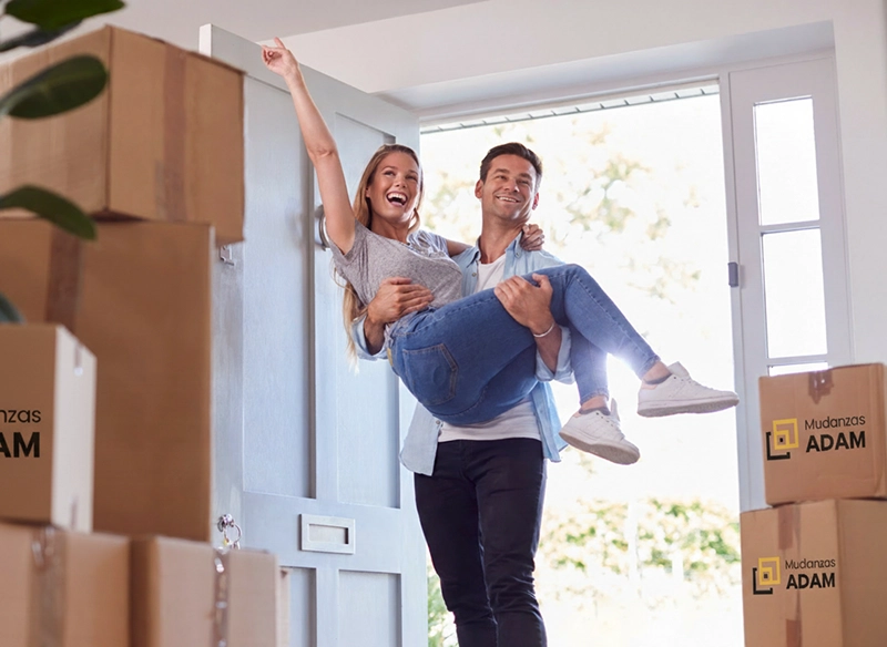 Una pareja entrando en casa tras hacer una mudanza internacional con Mudanzas Adam.