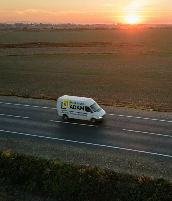 Vista aérea de una furgoneta de Mudanzas Adam por una carretera.