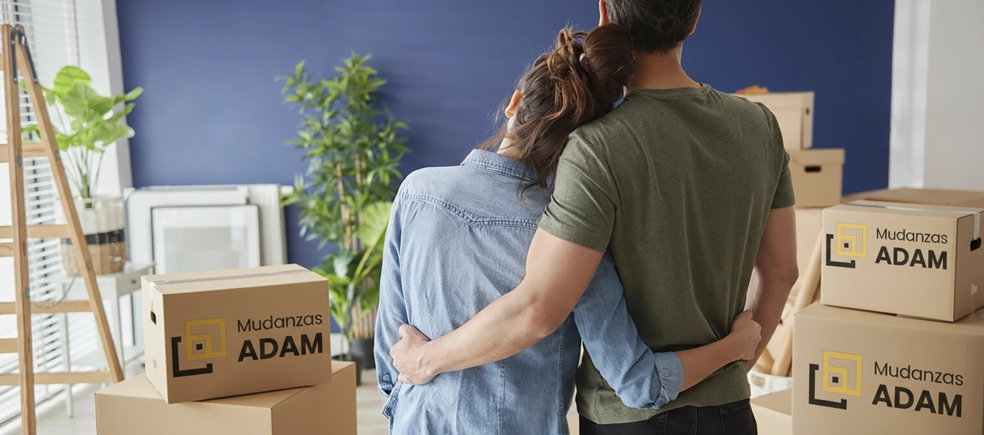 Pareja en su casa nueva con las cajas y los muebles embalados tras la mudanza.